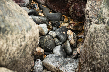 View of dark sea rocks against the ocean and cloudy sky. Preserved nature.