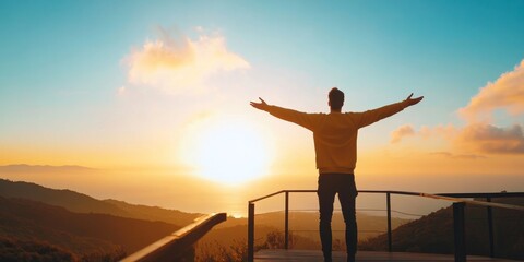 Fototapeta premium A person stands with arms outstretched, embracing the sunset over a tranquil landscape, symbolizing freedom and hope.