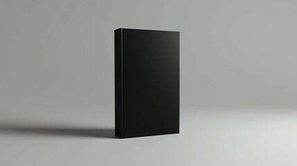 Minimalist black book standing upright on a white surface with a subtle shadow.