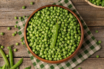 Fresh green peas and pods on wooden table, flat lay