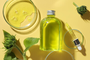 Petri dishes with cosmetic product, bottle, pipette and sunflowers on yellow background, flat lay