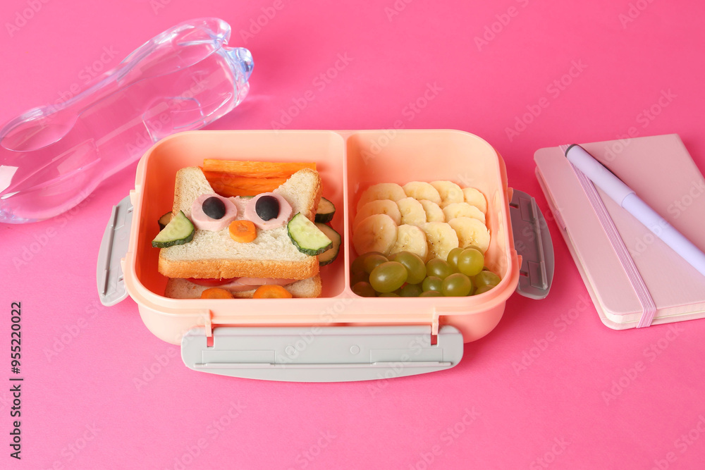 Wall mural Lunch box with snacks, bottle of water and stationery on pink background