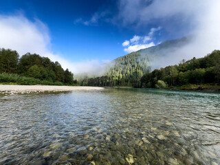 Skagit river in Washington state with clouds and Cascade mountains in background during summer morning