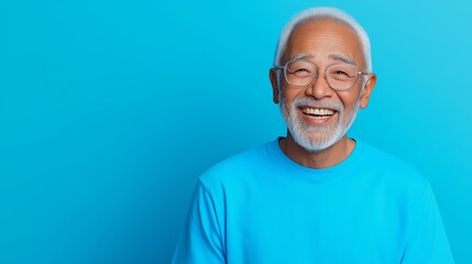 Obraz premium A man with a blue shirt and glasses is smiling. He is happy and enjoying himself. The blue background adds a sense of calmness and serenity to the scene