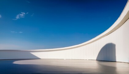 minimalist, modern architectural scene with a simple curved wall on the right side of an empty space, creating sharp lines and geometric shapes in white against a blue sky background. The focus is on 