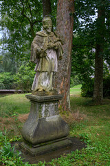 Obraz premium Statue of Saint John outside in the park.