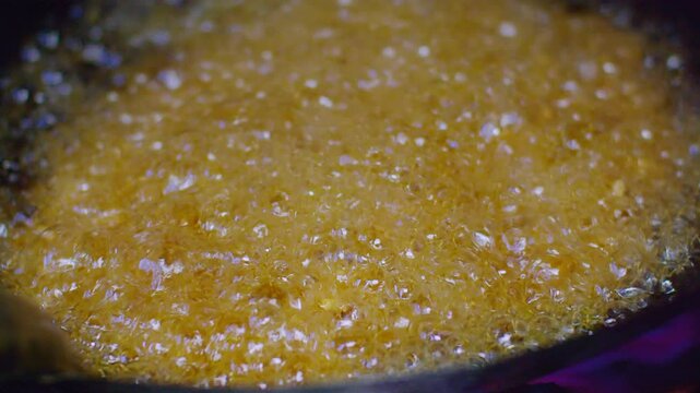 A detailed close-up shot of hot oil bubbling in a frying pan, ideal for culinary cooking and food preparation themes.