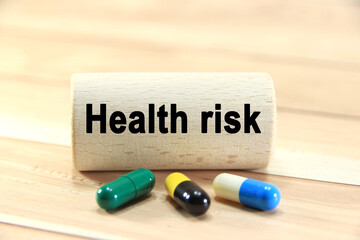 Health risk wording or text on wood block with capsule medicine.Copy space and business concept.