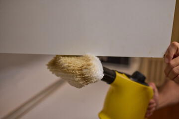 A man uses an innovative cleaning tool in his modern kitchen for cleanliness and organization