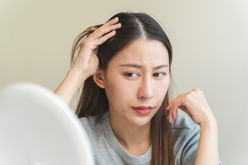 Young woman worrying about her thin hair and hair fall