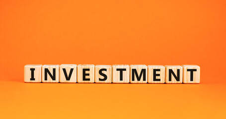 Investment symbol. Concept word Investment on beautiful wooden blocks. Beautiful orange background. Business investment concept. Copy space.
