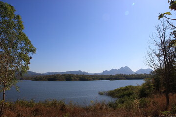 Natural tourist attractions with a large river, trees, and a bright sky background.