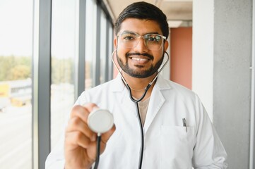 Portrait of happy friendly male Indian latin doctor medical worker wearing white coat with stethoscope. Medical healthcare concept