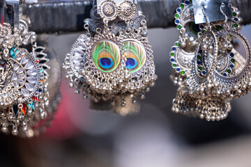 Traditional ethnic colorful silver earrings jewellery over blur background and copy space, Selective focus.