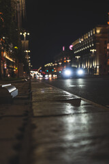 Fototapeta premium The night city of Minsk. Cars in the distance are driving along the avenue