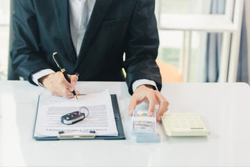 Car salesman signs car sales contract with cash and hands over keys to customer. Automotive business concept.