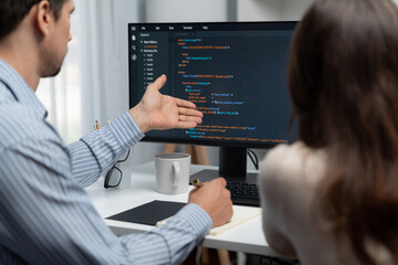 Team skilled developers program coding discussing creative website planning software project on two screen monitor's full stack data analyzing design at office with back side view concept. Postulate.