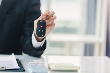 Car salesman signs car sales contract with cash and hands over keys to customer. Automotive business concept.