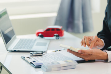 Car salesman signs car sales contract with cash and hands over keys to customer. Automotive business concept.