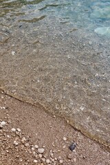 crystal clear water at the beach, wave coming into shore, background, aesthetic, shells, sand
