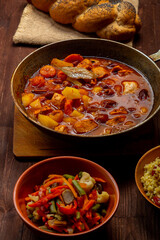 Hot cholent in a cast iron pan on the festive table for the Rosh Hashanah meal.