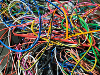 In the garage, after the work of an auto electrician, there are a lot of thin wires, tangled...