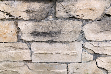 Rough Stone Wall Texture with Irregular Blocks. Close-up view of a rough stone wall composed of irregularly shaped blocks, showcasing natural textures and earthy tones.