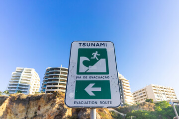 A tsunami evacuation sign at Praia da Rocha, Algarve, Portugal, guiding visitors to safety with...
