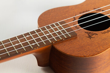 Fototapeta premium Close-up of Ukulele Hawaiian Guitar. a wooden ukulele with strings. musical instrument isolated on white, selective focus