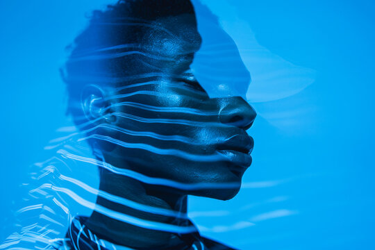 Blue-toned artistic portrait with light effects and shadow play