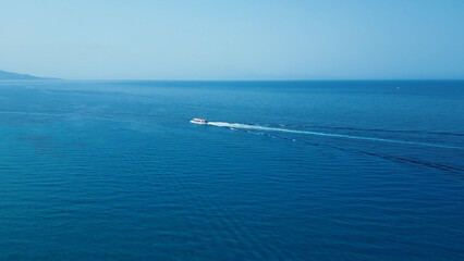 Vertical Aerial View of Deep Blue Sea Water with Yacht and Boat Leaving White Foamy Trail
