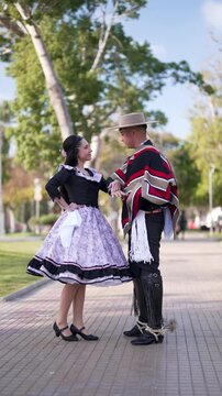 pareja de huasos chilenos bailando cueca en la plaza de la ciudad, concepto celebraci&oacute;n fiestas patrias 