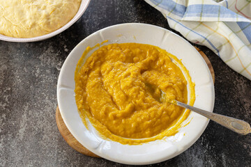 Instruction step 5. Freshly baked pumpkin cinnamon rolls or cinnabon with cream cheese on a rustic wooden table. Homemade seasonal autumn homemade pastry.