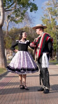 pareja de huasos chilenos bailando cueca en la plaza de la ciudad, concepto celebraci&oacute;n fiestas patrias 