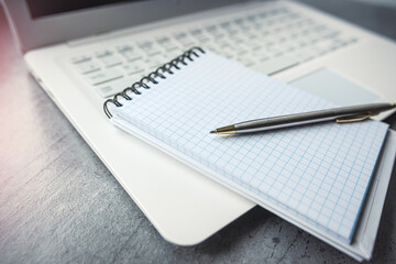 Office desk laptop computer with empty blank notebook pen, workplace at remote work