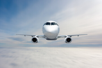 Front view of the white passenger jet plane flies in the air above the clouds