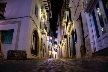 Christmas lights hanging from the balconies decorate the streets