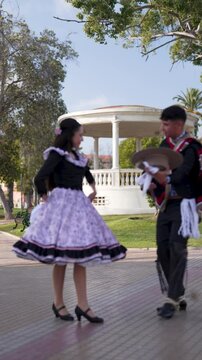 pareja de huasos chilenos bailando cueca en la plaza de la ciudad, concepto celebraci&oacute;n fiestas patrias 