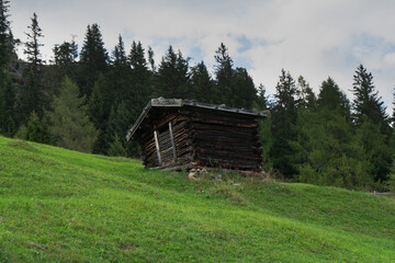 an old wooden barn, with alpine mountains in the background. austria, tirol