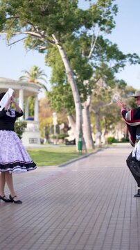 pareja de huasos bailando cueca chilena en la plaza de la ciudad