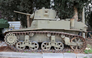 An old tank stands on the side of the road.