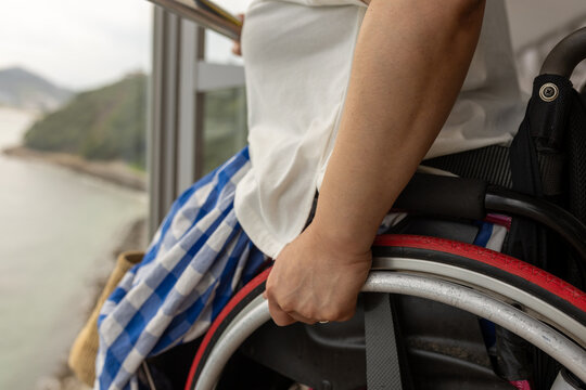 日本人の車椅子に乗った女性が車椅子の操作をしている手元