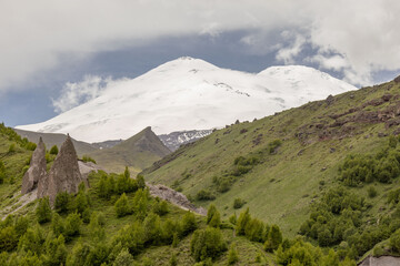 Weathering figures, teeth, against the backdrop of the snowy peaks of Elbrus