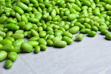 Fresh edamame soybeans on grey textured table, closeup