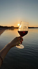 Glass of wine by the sea at sunset