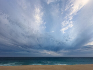 Green-blue ocean waters under cloudy sky