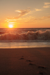 Sunset at sea during a storm. Coast with waves in sea on sunset. Waves in sea during storm and wind. Wave from the sea goes on land to the beach. Splashing Waves, Seaside. vertical