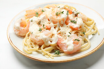Tasty pasta with shrimps, creamy sauce and cheese on white table, closeup