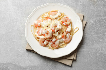 Delicious pasta with shrimps on light table, top view