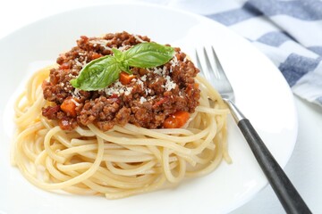 Tasty pasta bolognese on white table, closeup